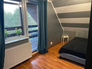 a bedroom with a bed and a large window at Ptasi dół in Sulęczyno