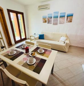 a living room with a table and a couch at Villa Arianna - Porto Pino in SantʼAnna Arresi