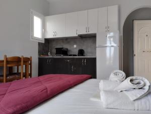 ein Schlafzimmer mit einem roten Bett und eine Küche in der Unterkunft Asteras Studios in Argostoli
