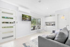 a living room with a couch and a kitchen at Mala Retreat Sleeps 7, Two Bedrooms & Ensuites in East Maitland