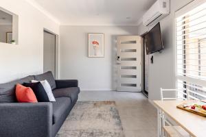 a living room with a couch and a tv at Mala Retreat Sleeps 7, Two Bedrooms & Ensuites in East Maitland