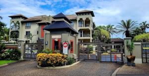 ein großes Haus mit einem Tor davor in der Unterkunft Paradise resort living one bedroom apartment in Westcourt