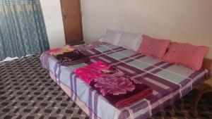 a bed with clothes on it in a room at Donmay homestay & guesthouse in Silapi