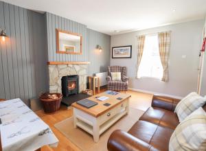 a living room with a couch and a fireplace at Larch in Newtonmore