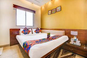 a hotel room with two beds and a window at FabHotel Khushi Regent - Near DB Mall in Bhopal