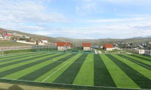 an empty soccer field with mountains in the background at Arena Hotel Dashkasan in Xoşbulaq