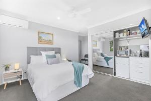a white bedroom with a large bed and a mirror at Mala Retreat Sleeps 7, Two Bedrooms & Ensuites in East Maitland
