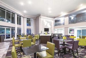 a restaurant with tables and yellow chairs at La Quinta by Wyndham Austin Airport in Austin