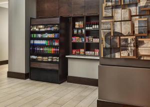 a grocery store aisle with a refrigerator and shelves of food at Hyatt Place Pena Station/Denver Airport in Denver