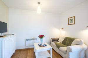 un salon avec un canapé et une table dans l'établissement Les Cottages du Lac A05, à Parentis-en-Born