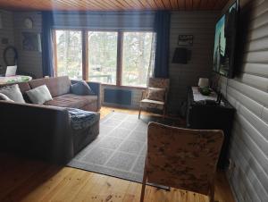 a living room with a couch and a chair at Ahlaistentupa in Pori