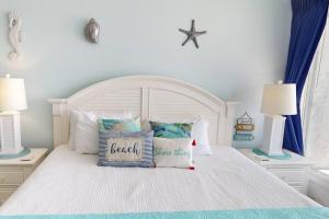 a bedroom with a white bed with a starfish on the wall at 318 - Island Inn in St. Pete Beach +42 photos