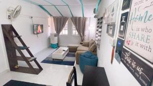 a living room with a couch and a ladder at Simple2 Guesthouse in Pantai Cenang