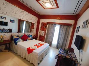 a bedroom with a bed and a television in it at Pagudpud Rinnovati in Pagudpud