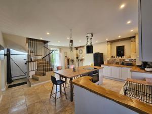a kitchen and living room with a table and chairs at Les Peupliers in Noyers-sur-Cher