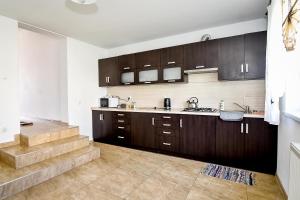 a kitchen with wooden cabinets and a staircase at Domek Na Brzysku Lipnica Wielka in Lipnica Wielka