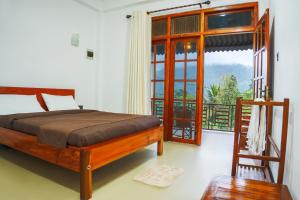 a bedroom with a bed and a large window at 3 Arch Villa in Ella