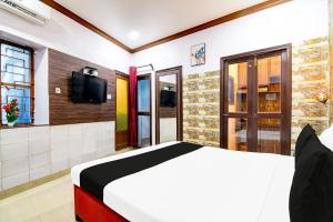 a bedroom with a bed and a tv on the wall at Collection O Karaya Road Formerly Hotel New Diamond in Kolkata