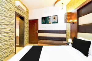 a hotel room with a bed and a bathroom at Collection O Karaya Road Formerly Hotel New Diamond in Kolkata +24 photos