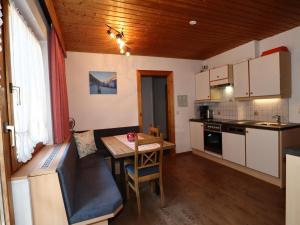 a living room with a table and a kitchen at Apartment in See near Bathing Lake in See +22 photos