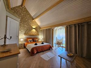 a bedroom with a bed and a chair in a room at Les Peupliers in Noyers-sur-Cher