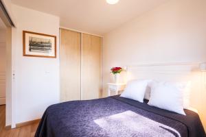 Appartement aux Cottages du Lac H70 في بارينتس إن بورن: غرفة نوم بسرير كبير مع وسائد بيضاء