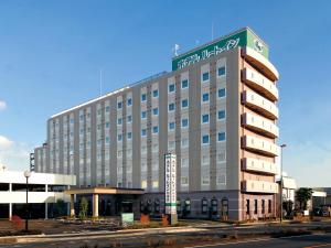 Un gran edificio con un cartel encima. en Hotel Route-Inn Sagamihara -Kokudo 129 Gou-, en Sagamihara