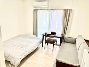 una camera da letto con un letto, un tavolo e una sedia di Villa Hayabusa ad Osaka Altre 17 foto