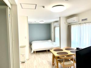 una piccola stanza con un letto e un tavolo di Villa Hayabusa ad Osaka