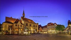 NiederdorlaFerienwohnung in Bodensee Niedersachsen Harz的晚上有钟楼的大楼