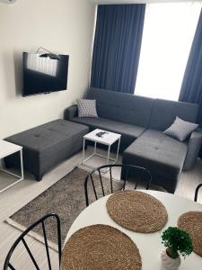 a living room with a couch and a table and chairs at HADRİANS TOWER in Antalya