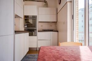 una cucina con mobili bianchi e un tavolo di Vigna Stelluti a Roma