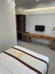 a hotel room with a bed and a flat screen tv at Tùng Lâm Hotel in Bắc Hà