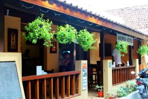 um restaurante com vasos de plantas na frente dele em Andrea Hotel em Yogyakarta