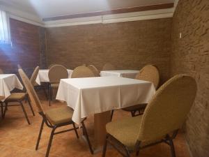 a dining room with white tables and chairs at Berekfürdő vendégház in Berekfürdő