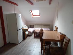 a small room with a refrigerator and a table and chairs at Berekfürdő vendégház in Berekfürdő