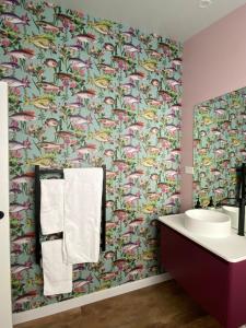 baño con papel pintado con motivos florales y lavamanos en New two bedroom close to town, en Taupo