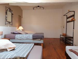a bedroom with two beds and a table with a mirror at Auberge de Miélandre in Teyssières