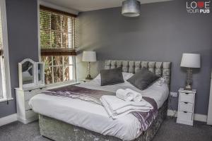 een slaapkamer met een groot bed met handdoeken erop bij The Robin Hood Inn in Rowlands Castle