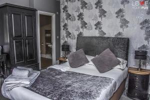 een slaapkamer met een bed met twee kussens erop bij The Robin Hood Inn in Rowlands Castle