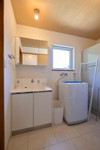 a bathroom with a sink and a mirror at Poroto House in Nanae