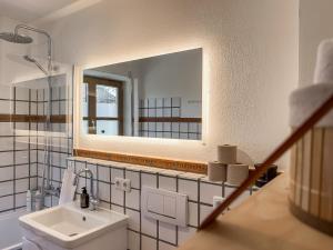 un baño con lavabo y espejo en Apartment für 6 - Bergblick, Balkon, Kamin, Kino, Yoga, Parkplatz, en Garmisch-Partenkirchen 28 fotos más