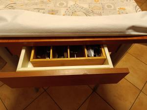 a wooden drawer on a table next to a bed at Mansarda Eiretta in Ceres