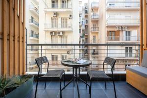 a balcony with a table and chairs on a balcony at City Vibe-Siggrou 44 family in Thessaloniki +3 photos