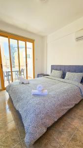 a large bed with a towel on top of it at Central City Rooms in Larnaka
