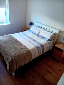 a bedroom with a large bed with a wooden floor at Spacious Apartment, Enniscrone in Enniscrone