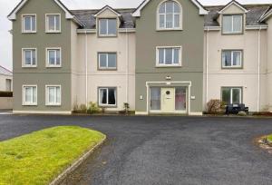 a large house with a driveway in front of it at Spacious Apartment, Enniscrone in Enniscrone