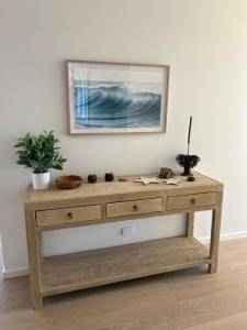 een houten dressoir in een kamer met een foto aan de muur bij Coast in Stokes Bay