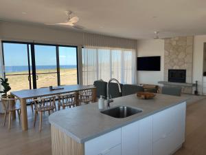 une cuisine et un salon avec vue sur l'océan dans l'établissement Coast, à Stokes Bay