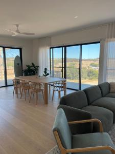 een woonkamer met een bank, een tafel en stoelen bij Coast in Stokes Bay